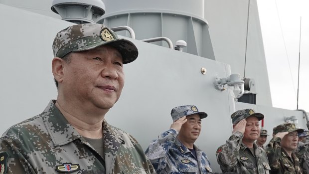 Chinese President Xi Jinping, left, prepares to address the troops after reviewing the People\'s Liberation Army Navy fleet in the South China Sea. 