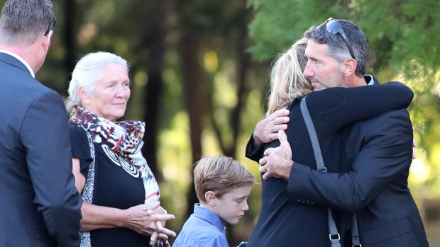 Aaron Cockman (right) is greeted by family and friends outside Bunbury Crematorium.