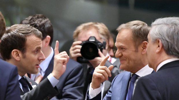 We're in: French President Emmanuel Macron, left, speaks with European Council President Donald Tusk in Brussels.