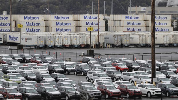 New cars and cargo containers wait in Tacoma, Washington.