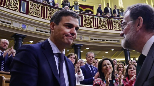 Spain's Prime Minister Mariano Rajoy, right, shakes hands with socialist leader Pedro Sanchez after a motion of no confidence vote at the Spanish parliament in Madrid.
