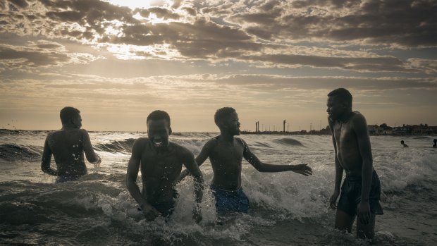 Highly commended by the Moran Prize judges, Matthew Abbott's Wrestlers Cooling Off depicts young South Sudanese men at a beach in Melbourne. 