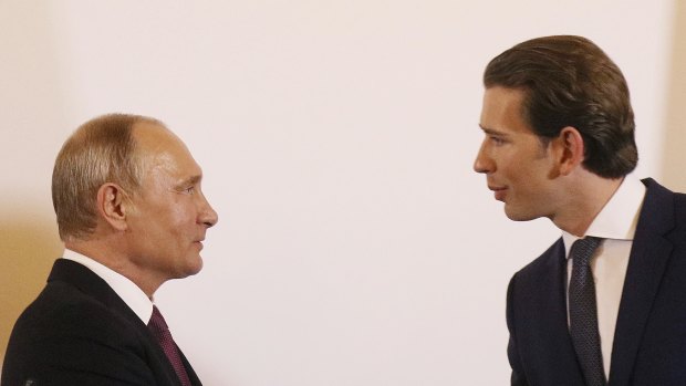 Austrian Chancellor Sebastian Kurz, right, shakes hand with Russian President Vladimir Putin.