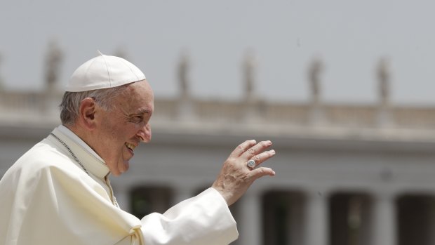 Pope Francis waves to faithful