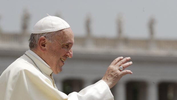 Pope Francis waves to faithful