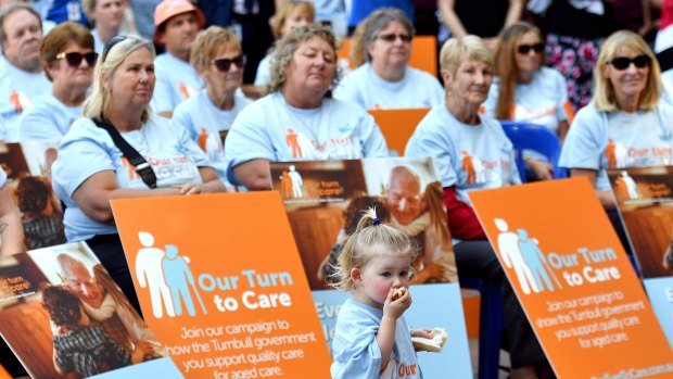 A child is seen with Health Services Union members and other affiliated unions members at a rally at Hyde Park in Sydney in April.