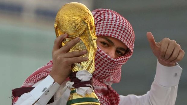 A Qatari youth holds a mock World Cup trophy during celebrations in Doha.