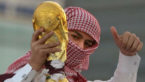 A Qatari youth holds a mock World Cup trophy during celebrations in Doha.