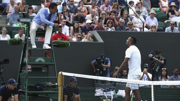 Kyrgios receives a warning for bad language from umpire James Keothavong as he plays Robin Haase.