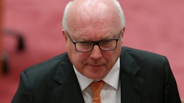George Brandis was supposed to take up his post as High Commissioner to the UK next week but he has injured his heel playing tennis. 