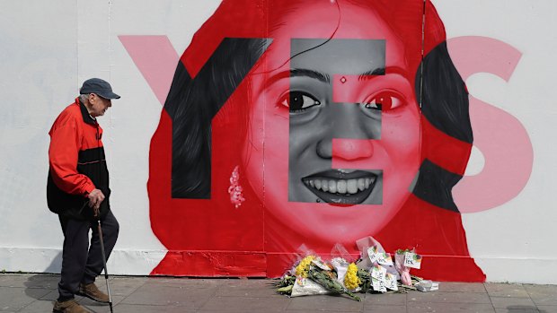 A man walks past a mural showing Savita Halappanavar, a 31-year-old Indian dentist who had sought and been denied an abortion before she died after a miscarriage in a Galway hospital.