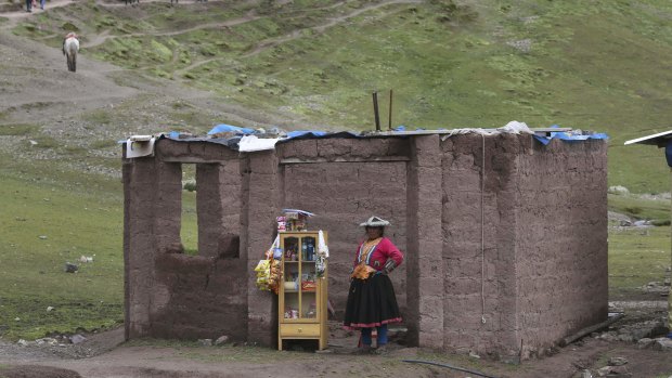 An Andean woman sells sweets, water and chips on the route to Rainbow Mountain.
