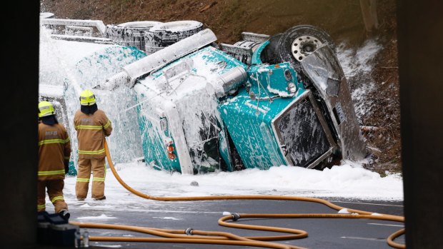 Firefighters douse foam on the petrol tanker on the Calder Freeway.