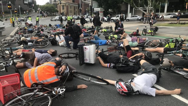 Cyclists stage a "die-in" protest during Brisbane's peak hour traffic.
