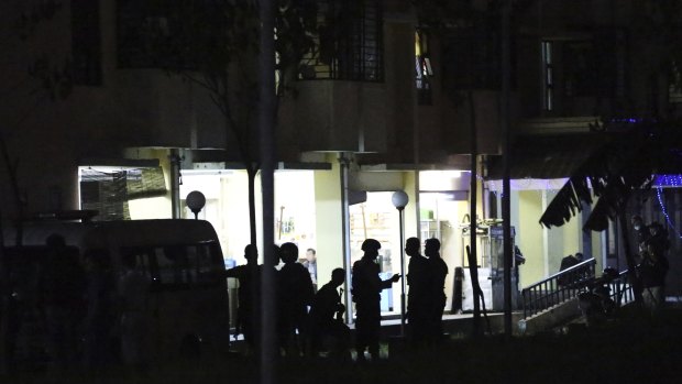 Indonesian police stand guard in front of an apartment building after an explosion. 