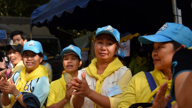 Thai volunteers applaud firefighters at the rescue base camp.