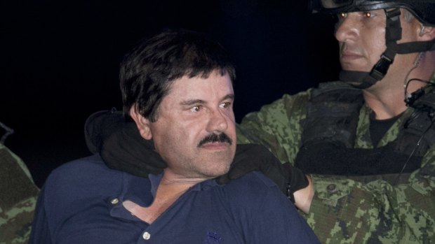 Joaquin "El Chapo" Guzman is made to face the press as he is escorted to a helicopter in handcuffs by Mexican soldiers and marines in January 2016.