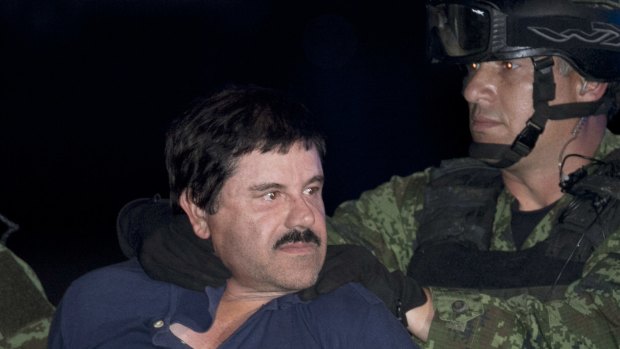 Joaquin "El Chapo" Guzman is made to face the press as he is escorted to a helicopter in handcuffs by Mexican soldiers and marines in January 2016.