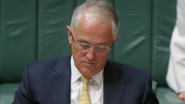 Prime Minister Malcolm Turnbull with the defence white paper during question time on Thursday.