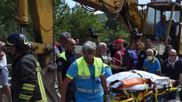 ACCUMULI, ITALY - AUGUST 24: Rescue workers retrieve a dead body in a damaged building on August 24, 2016 in Accumuli, Italy. Central Italy was struck by a powerful, 6.2-magnitude earthquake in the early hours, which has killed at least three people and devastated dozens of mountain villages. Numerous buildings had collapsed in communities close to the epicenter of the quake near the town of Norcia in the region of Umbria, witnesses told Italian media, with an increase in the death toll highly likely (Photo by Giuseppe Bellini/Getty Images)