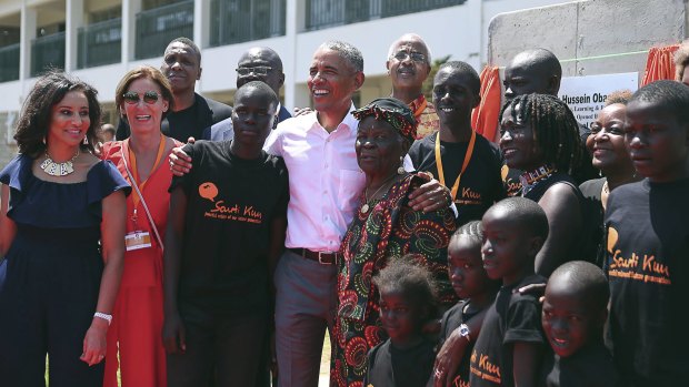 Barack Obama, centre, with his step Grandmother Sarah, centre right, his half sister Auma, third right, along with children and  officials, during an event in Kogelo, Kenya, on Monday.