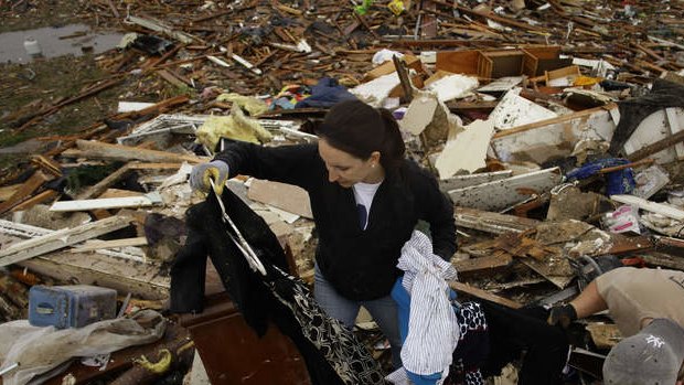 Kalissa Graham retrieves her belongings from her destroyed home with the help of her friend Derick Colwell in Moore, Oklahoma.