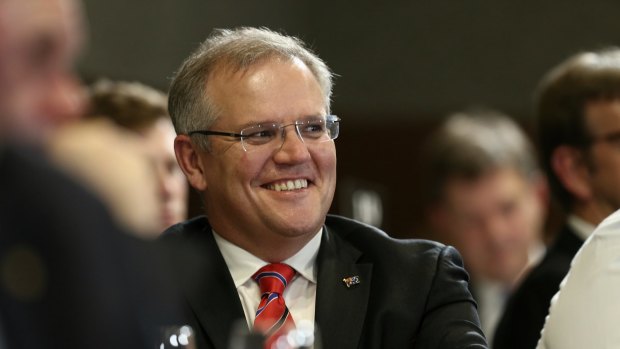 Social Services Minister Scott Morrison listens as Prime Minister Tony Abbott addresses the National Press Club in Canberra on Monday.