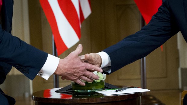 President Donald Trump shakes hands with Russian President Vladimir Putin on Monday.