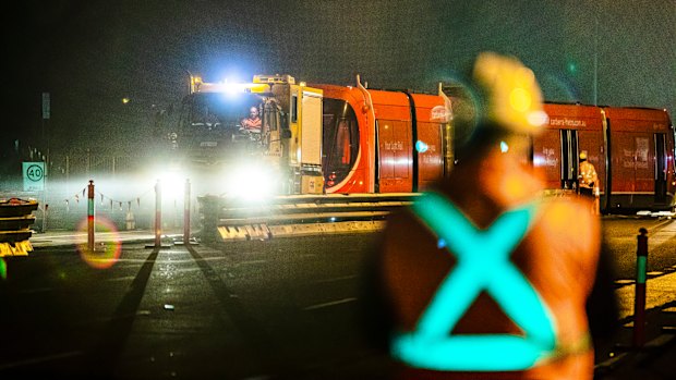 A light rail vehicle is dragged on to the tracks on Flemington Road for testing on Monday night