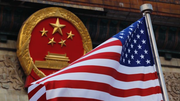 American flag is flown next to the Chinese national emblem.