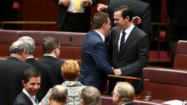 Senator Matthew Canavan is congratulated by Senator James McGrath after delivering his first speech. Photo: Alex Ellinghausen