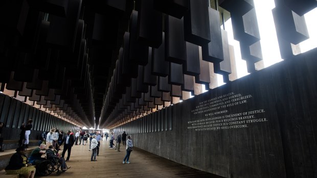 Visitors walk through the National Memorial for Peace and Justice in Montgomery, Alabama. 