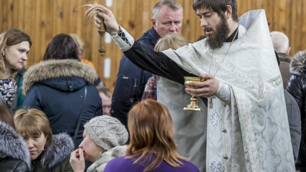 A Russian Orthodox priest conducts a requiem for the victims of the fire in Kemerovo, Russia.