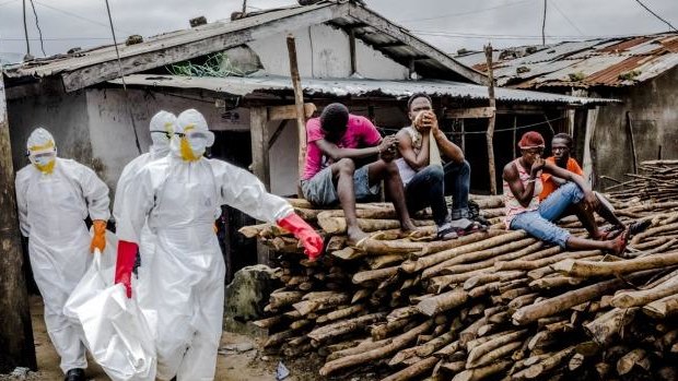 A burial team removes the body an Ebola victim from an isolation ward in West Point, Monrovia.