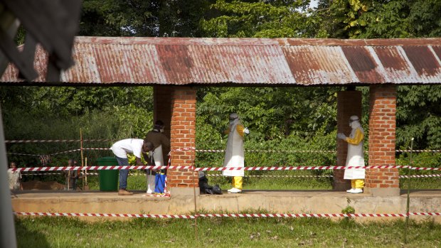 Health workers are sprayed with chlorine after leaving the isolation ward to diagnose and treat suspected Ebola patients, at Bikoro Hospital in Bikoro, the rural area where the Ebola outbreak was announced in early May in Congo. 