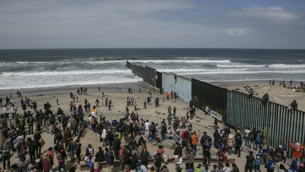 Hundreds of migrants from Central America who travelled in a caravan through Mexico gather with supporters at the border wall where it ends at the Pacific Ocean, in Tijuana, Mexico, on April 29.