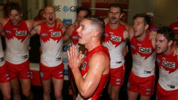 Sydney Swans first gamer Ben Ronke sings the team song after his first win. 