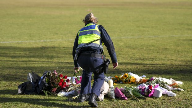 A female police officer lays flowers at the scene where Eurydice Dixon\'s body was found. 15 June 2018. The Age News. Photo: Eddie Jim.
