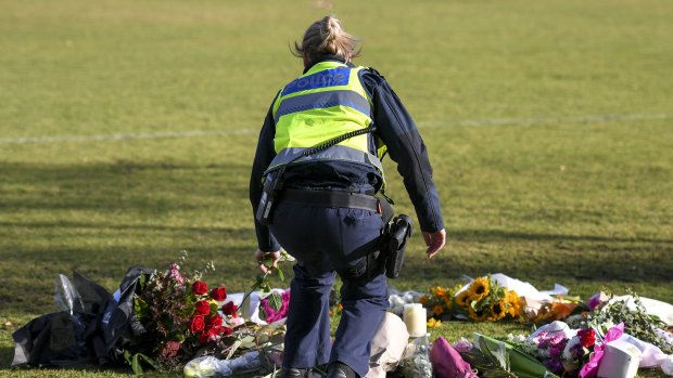 A female police officer lays flowers at the scene where Eurydice Dixon\'s body was found. 15 June 2018. The Age News. Photo: Eddie Jim.