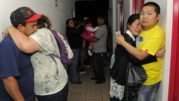 People embrace on the upper floor of an apartment building located a few blocks from the coast where they gathered to avoid a possible tsunami after an earthquake in Iquique, Chile, Tuesday, April 1, 2014. A powerful magnitude-8.2 earthquake struck off Chile's northern coast Tuesday night.