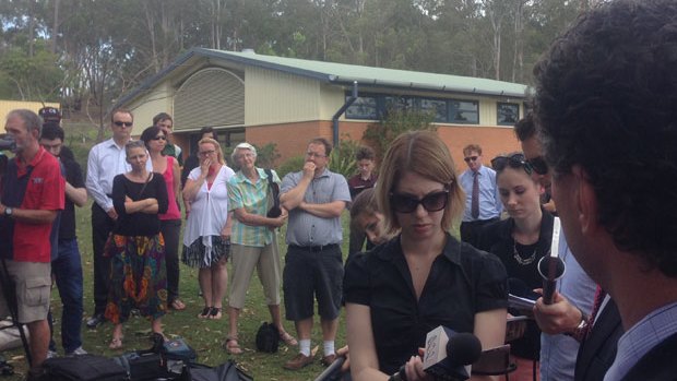 A crowd of concerned parents and students surround the government press conference announcing the school closure.