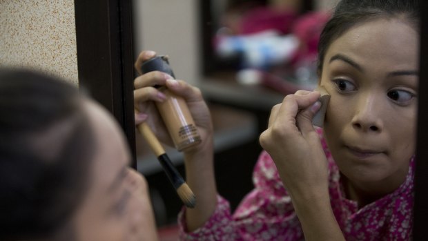 Johandrys Colls practices applying makeup during a class at the Belankazar Modeling Academy in Caracas.

