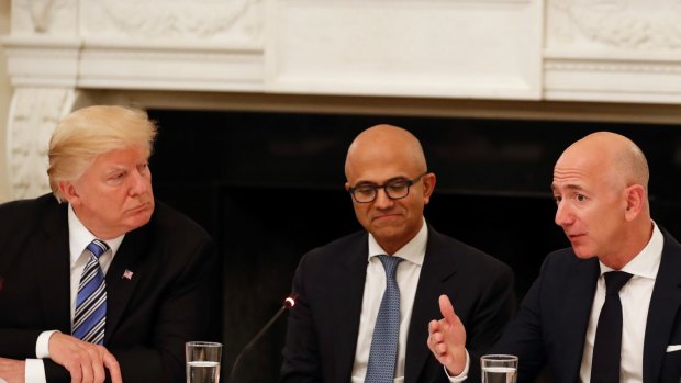 Not much love lost: Donald Trump (with Microsoft CEO Satya Nadella in the centre) and Amazon boss Jeff Bezos during an American Technology Council roundtable at the White House last year.