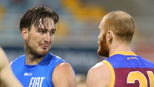 Charlie Dixon of the Suns and Daniel Merrett of the Lions exchange words in round 19.