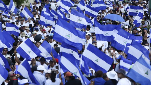 Demonstrators protesting government repression wave Nicaraguan flags in Managua.