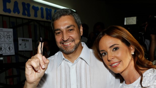 Paraguayan presidential candidate Mario Abdo Benitez of the Colorado Party shows his finger inked after casting his vote, accompanied by his wife Silvana Lopez Moreira, in Asuncion.