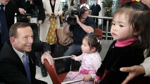 Opposition leader Tony Abbott meets with children at a Nunawading car dealership in Victoria on Friday.