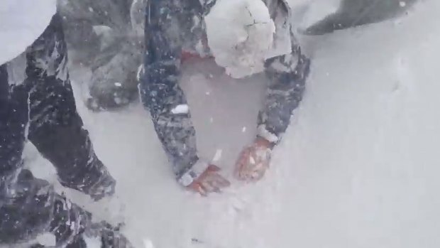 A person attempts to get to their feet after the avalanche swept through.