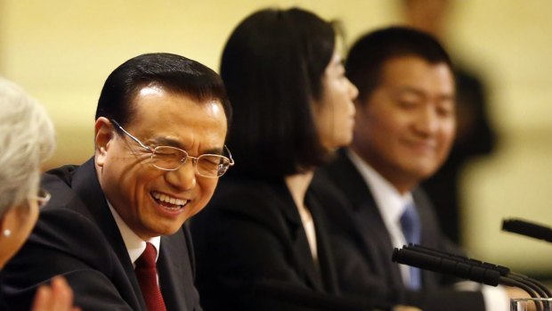 Chinese Premier Li Keqiang, centre, laughs during the international press conference.