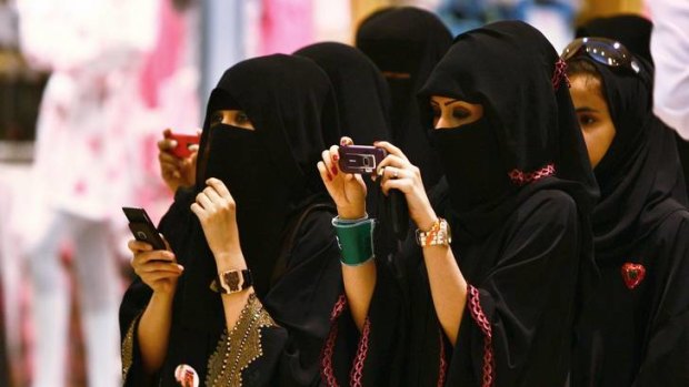 Veiled Saudi women take photos of their children during a ceremony to celebrate Saudi Arabia's Independence Day.